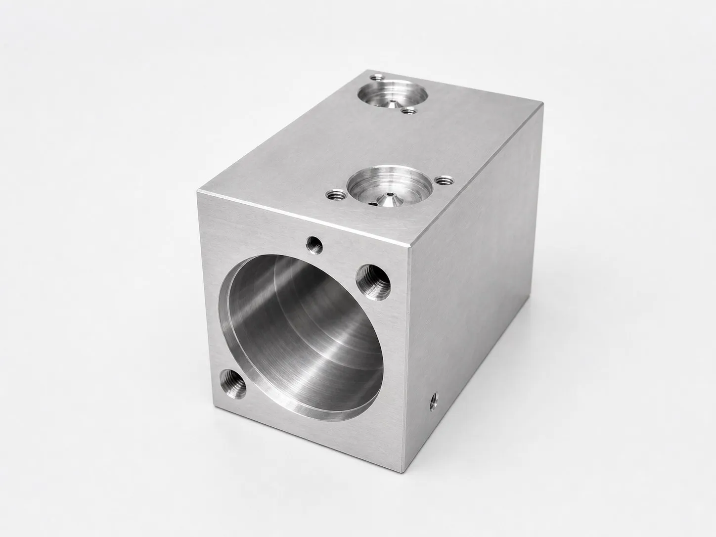 Precision-machined aluminum block with cavities, threaded holes, and finishing.
